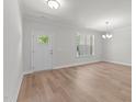 Bright living area with hardwood floors, large window, and a contemporary light fixture at 50 Arbor Dr, Youngsville, NC 27596