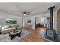 Cozy living room with wood floors, stone fireplace, and open view to the kitchen at 593 Bailey Rd, Coats, NC 27521