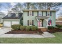 Two-story green house with attached garage and manicured lawn at 107 Coatbridge Cir, Cary, NC 27511