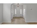 Bright entryway with wood flooring, white walls, modern light fixture and lots of natural light at 209 Meadowbark Bnd # 20, Garner, NC 27529