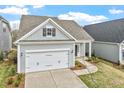 Stylish home with a two-car garage, attractive gray siding, and a neatly landscaped yard, blending comfort and style at 209 Meadowbark Bnd # 20, Garner, NC 27529