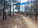 Gravel driveway entrance with wooden fence and metal gate at 330 Ellis Stewart Ln Ln, Cameron, NC 28326