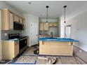 A kitchen featuring light wood cabinets, stainless steel appliances, and a central island with pendant lighting at 356 Maidenhair Pl, Clayton, NC 27520