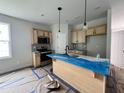Bright kitchen boasts light wood cabinets, stainless steel appliances, and a functional island with sink and pendant lighting at 356 Maidenhair Pl, Clayton, NC 27520
