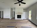 Open living room with a ceiling fan, fireplace with a wood mantle, and built-in shelving provides an inviting space at 356 Maidenhair Pl, Clayton, NC 27520