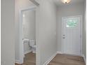 Entryway with a half bathroom, wood-look floors, and a white front door with glass panels at 3854 Well Fleet Drive, Fuquay Varina, NC 27526