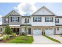 New townhome showcasing a stone facade, white siding, black shutters, and a two-car garage at 3860 Well Fleet Drive, Fuquay Varina, NC 27526