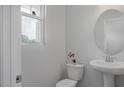 Cozy powder room featuring pedestal sink, toilet, and window for natural light at 3860 Well Fleet Drive, Fuquay Varina, NC 27526