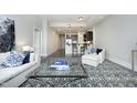 Open-concept living room leading to the kitchen, featuring a sofa and large area rug at 400 W North St # 620, Raleigh, NC 27603