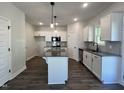 Bright kitchen features white cabinets, granite countertops, a kitchen island, and stainless steel appliances at 406 Maidenhair Pl, Clayton, NC 27520