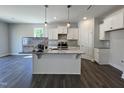 Bright kitchen featuring granite countertops, white cabinets, an island, and stainless steel appliances at 45 Mossman Ct, Zebulon, NC 27597
