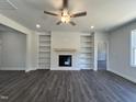 Spacious living room with built-in bookshelves, a fireplace, and hardwood flooring at 45 Mossman Ct, Zebulon, NC 27597