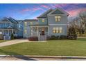 Charming two-story home with a covered front porch and lush green lawn at 700 Coleman St, Raleigh, NC 27610