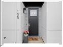 Contemporary black front door with a welcome mat and potted plants at 712 E Edenton St # 105, Raleigh, NC 27601