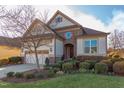 Two-story house with stone and shingle exterior, two-car garage, and manicured lawn at 7845 Hasentree Lake Dr, Wake Forest, NC 27587