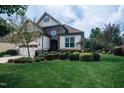 Two-story house with stone and shingle exterior, two-car garage, and manicured lawn at 7845 Hasentree Lake Dr, Wake Forest, NC 27587