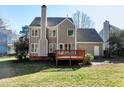 View of back exterior with deck, spacious backyard, and a well-maintained lawn at 1002 Santa Rosa Dr, Apex, NC 27502