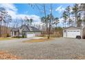 House with detached garage and a large gravel driveway at 1134 Bowling Mountain Dr, Stem, NC 27581