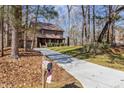 Scenic view of a beautiful two-story home with a long driveway surrounded by lush trees at 11509 Hardwick Ct, Raleigh, NC 27614