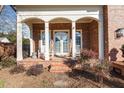 Brick porch with white columns, double doors, and comfortable seating at 2035 Stuart Ct, Burlington, NC 27215
