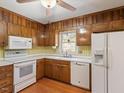 Traditional kitchen features wooden cabinetry, white appliances, and a window over the sink at 2509 Foxgate Dr, Raleigh, NC 27610