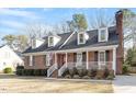 Cape Cod style home featuring brick facade, dormer windows, shutters, and front porch at 2612 Hiking Trl, Raleigh, NC 27615