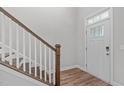 Wooden staircase with white railings in a light-colored hallway at 3048 Curling Creek Dr, Apex, NC 27502