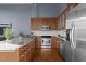 Modern kitchen with wood cabinets, granite counters, and stainless steel appliances at 500 N Duke St # 56-207, Durham, NC 27701