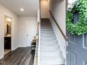 Welcoming entryway with hardwood floors, staircase, and a view into the downstairs bathroom at 5238 Beardall St, Raleigh, NC 27616
