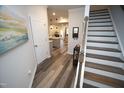 Welcoming foyer with wood floors, staircase, and view of the open-concept kitchen and living areas at 5806 Empathy Ln, Raleigh, NC 27616