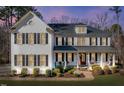 Two-story home boasts a brick facade, shutters, and a welcoming front porch at 1141 Barley Stone Way, Raleigh, NC 27603