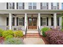 Inviting front porch with a double glass door, white pillars, and landscaping at 1141 Barley Stone Way, Raleigh, NC 27603
