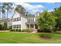 Beautiful white brick home with black shutters, a manicured lawn, and mature trees at 1141 Barley Stone Way, Raleigh, NC 27603