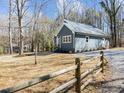 View of the side of the house and a gravel driveway, surrounded by a yard with trees at 125 Sue-Kim Dr, Youngsville, NC 27596