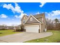 Two-story house with a large garage and landscaped lawn at 130 Daniel Farm Dr, Benson, NC 27504