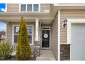 Charming home entrance with black door, decorative wreath, stone accents, and manicured landscaping at 130 Daniel Farm Dr, Benson, NC 27504