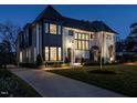 An elegant home with a well-lit walkway leading to the entrance, highlighting the beautiful architecture at dusk at 1324 Brooks Ave, Raleigh, NC 27607
