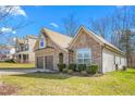 Side view of a charming two-story house with stone and siding, two-car garage at 2242 Colorado Dr, Graham, NC 27253