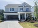 Two-story home with gray siding, a two car garage, manicured lawn, and a covered front porch at 250 Tidal Pool Way, Cary, NC 27519
