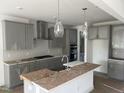 A modern kitchen with gray cabinets, stainless steel appliances and a subway tile backsplash at 250 Tidal Pool Way, Cary, NC 27519