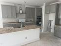 Unfinished kitchen featuring gray cabinets, a center island, and stainless steel appliances at 250 Tidal Pool Way, Cary, NC 27519