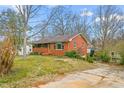 Brick ranch house with a driveway and mature trees at 2581 Hyde St, Burlington, NC 27217