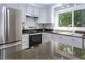 Bright kitchen with stainless steel appliances and dark countertops at 326 W Bywood Dr, Durham, NC 27712
