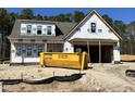 New construction home featuring a two-car garage and bright white exterior under a clear, sunny sky at 387 E Clydes Point Way, Wendell, NC 27591