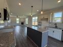 Open concept kitchen showcasing granite counters, center island, and seamless flow into the living area with fireplace at 59 Pretty Run Branch Ln, Wendell, NC 27591