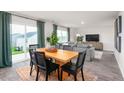 Dining area with wood table, gray chairs, and view to living room at 6020 Sodium St, Raleigh, NC 27610