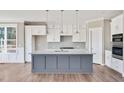 Modern kitchen with white cabinets, gray island, and quartz countertops at 7723 Barefoot Rd, Fuquay Varina, NC 27526