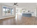 Open concept kitchen with gray island, white cabinets, and stainless steel appliances at 7723 Barefoot Rd, Fuquay Varina, NC 27526