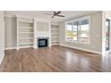 Spacious living room with hardwood floors, built-in shelving, and a fireplace at 7723 Barefoot Rd, Fuquay Varina, NC 27526