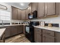 Modern kitchen with dark wood cabinets and black appliances at 117 Hinshaw Shop Rd, Liberty, NC 27298